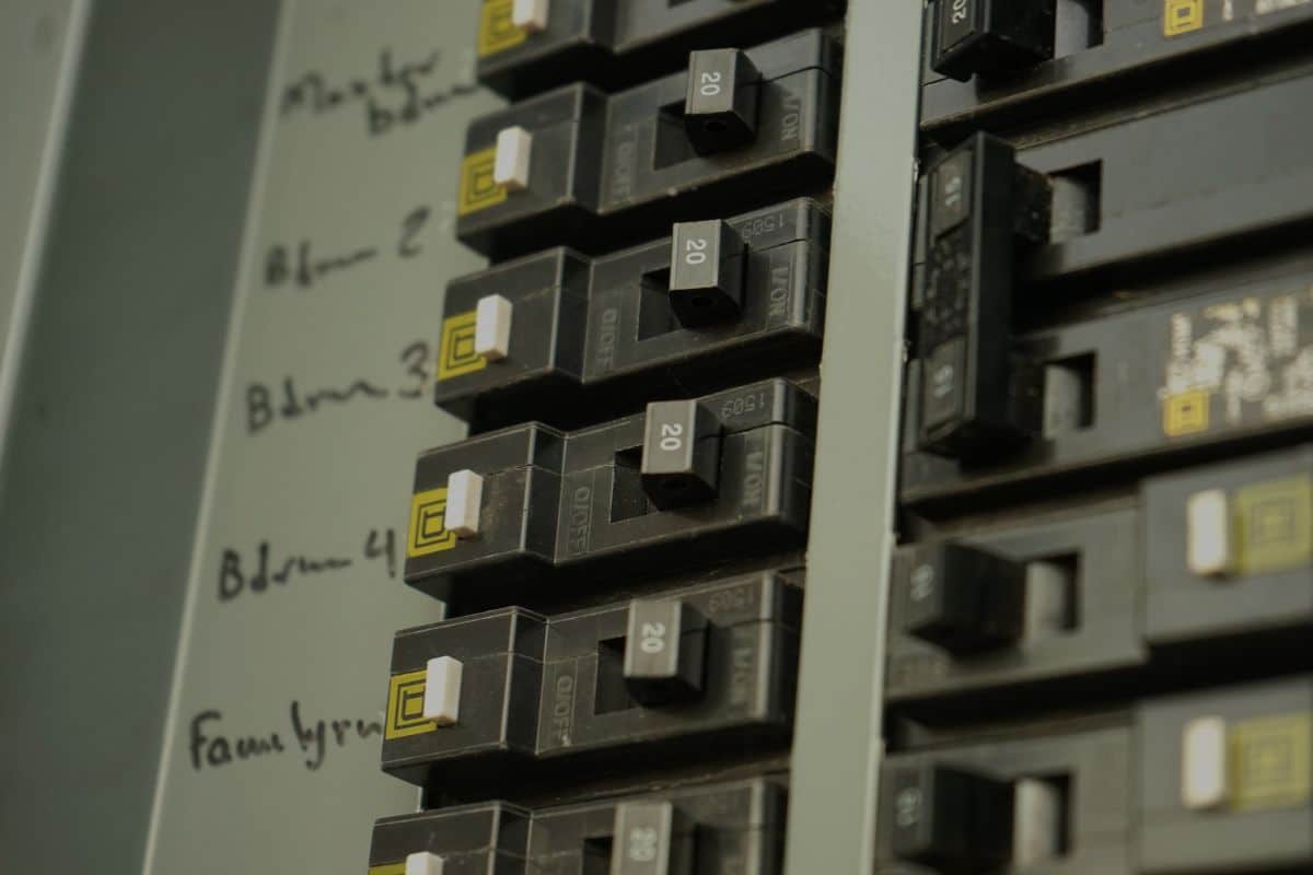Handwritten circuit labels beside 20-amp breakers inside a residential electrical panel